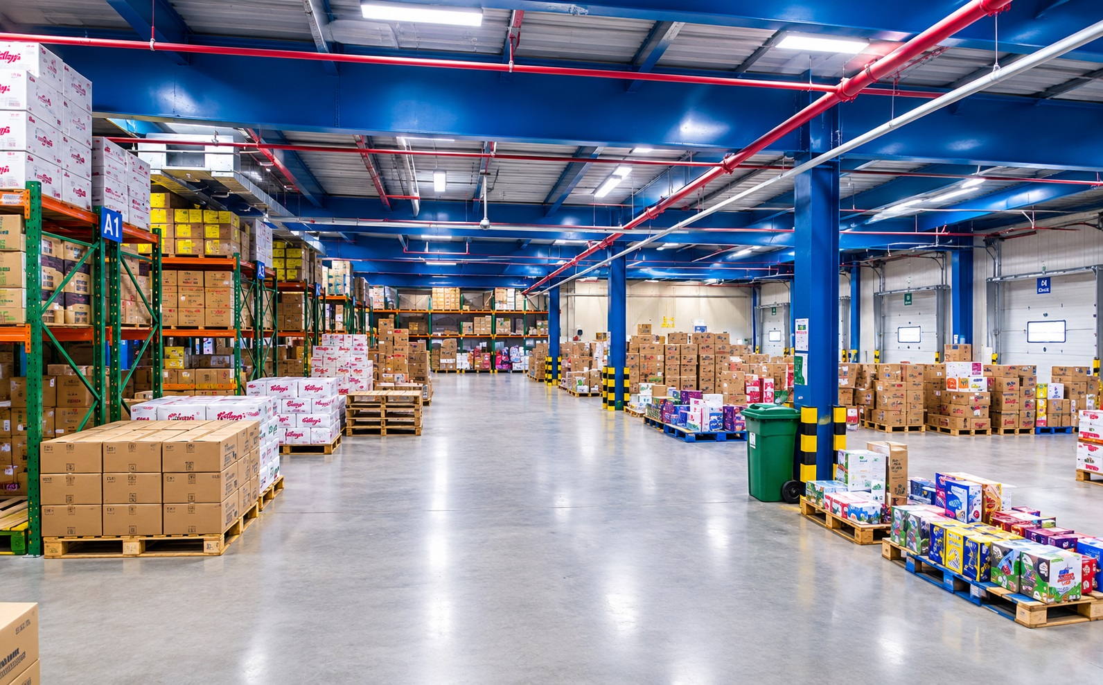 Staff with trolleys on the warehouse floor among mixed pallets